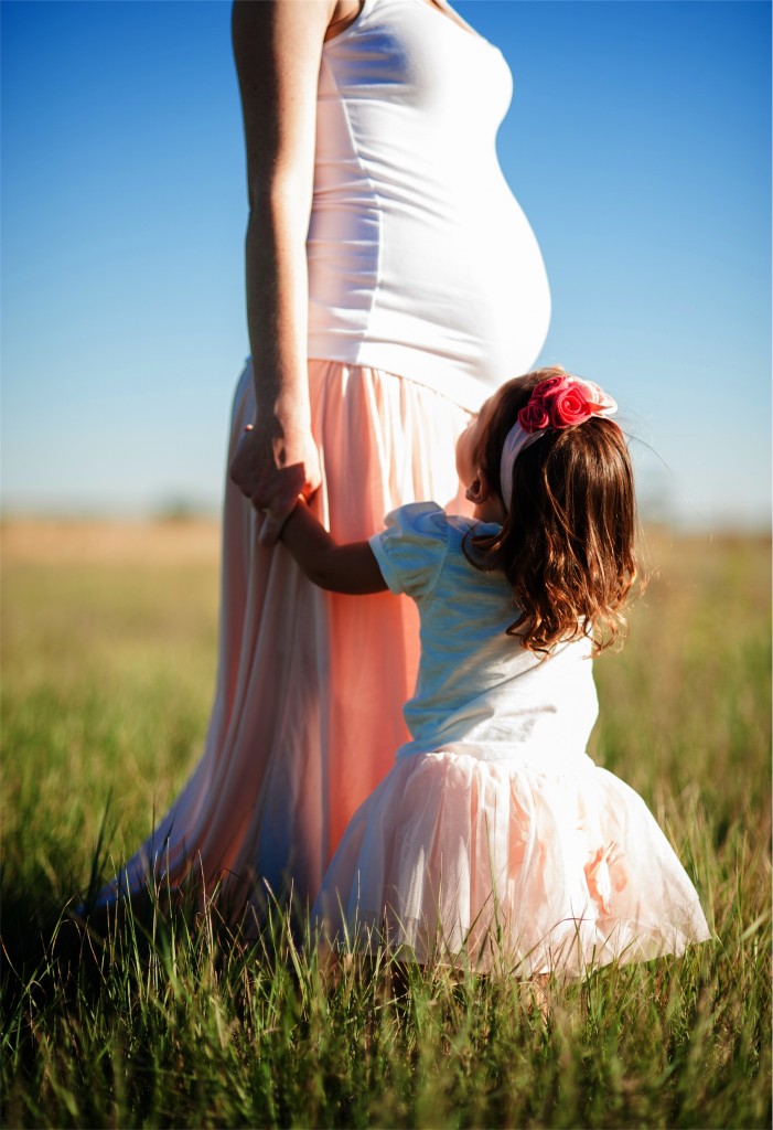 Pregnant Woman Walking in the Field with Her Daughter