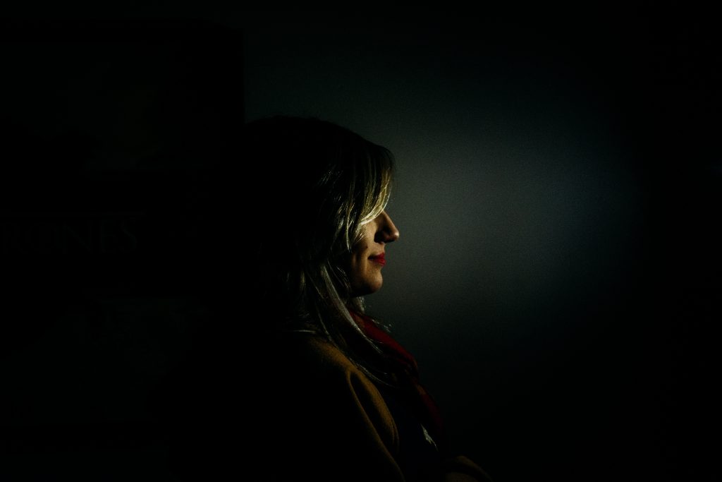 Woman with Half Smile Standing in the Dark