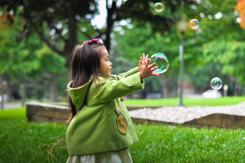 Little Asian Girl Popping Bubbles